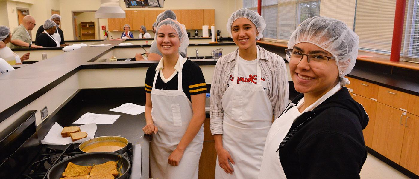 Students in a kitchen classroom preparing food